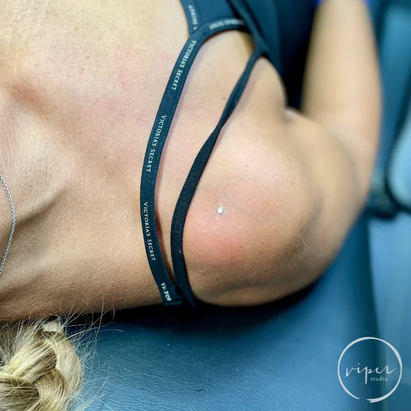 Jemný microdermální piercing na tváři