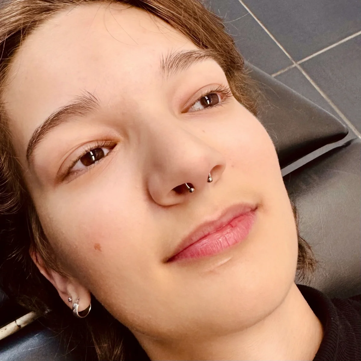 Septum piercing — mladá dívka s lehkým úsměvem