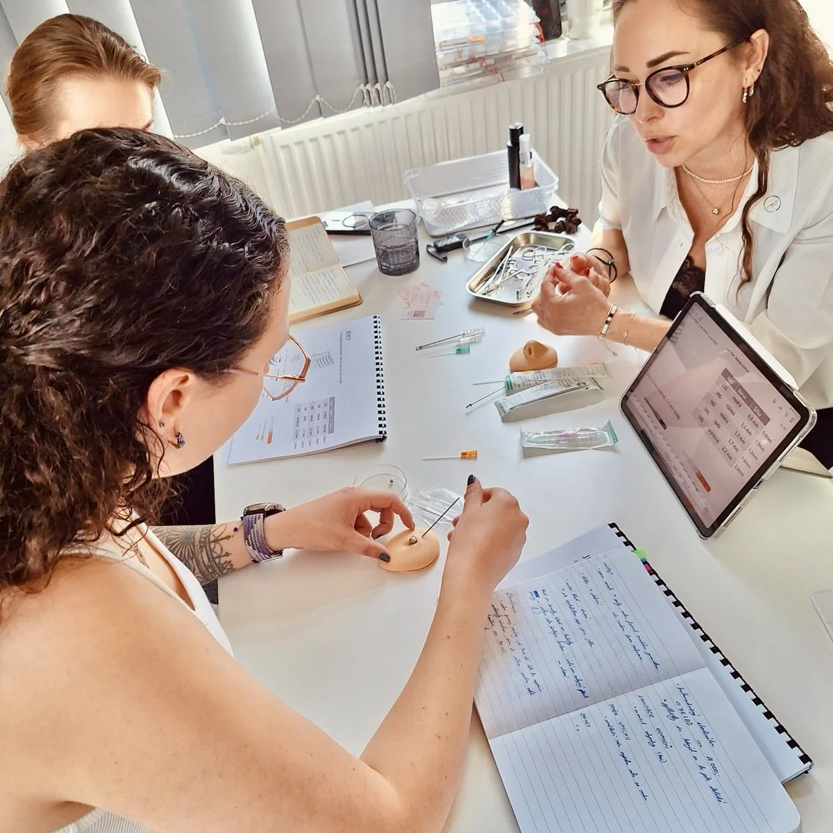 Teoretická výuka piercingu — práce s tabletem, poznámkami a modelem